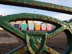 Beach huts seen through the beach railings